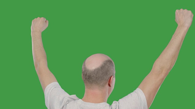 绿色背景下的足球比赛中，球迷举起双手庆祝进球。成功的概念。Alpha通道，绿色屏幕视频下载