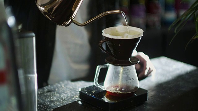 往磨碎的咖啡上倒热水的日本咖啡师视频素材