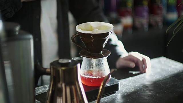 日本咖啡师将热水倒在磨碎的咖啡上(慢镜头)视频素材