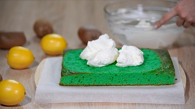 将马斯卡泊尼乳酪涂在绿色海绵蛋糕上。视频下载