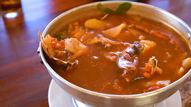 泰国汤，海鲜和混合蔬菜在橙色辣罗望子和香料汤。视频购买