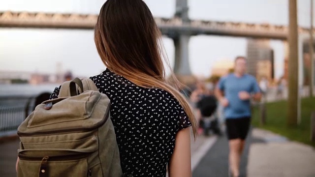 镜头跟随年轻的女游客背包在阳光灿烂的布鲁克林公园漫步纽约慢镜头视频素材