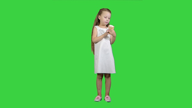 小女孩在绿屏上吃冰淇淋，色度钥匙视频下载