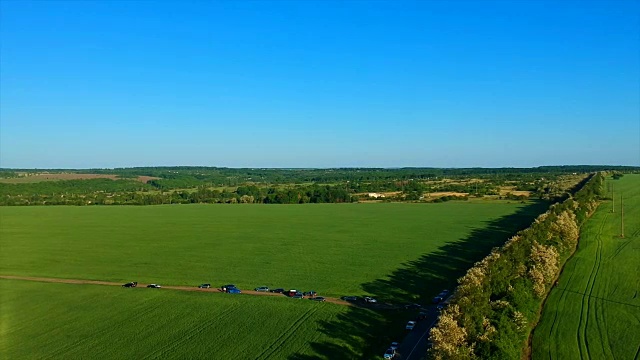 一望无际的绿色稻田，映衬着群山如画的遥远村庄视频素材