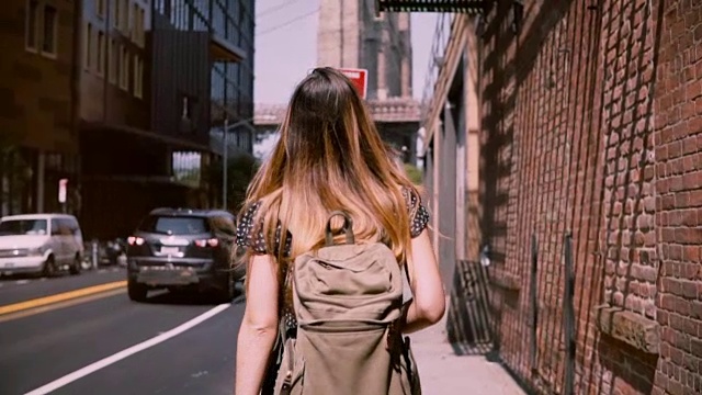 镜头跟随戴着时尚太阳镜的白人女游客在纽约的老街上探索，慢镜头视频下载