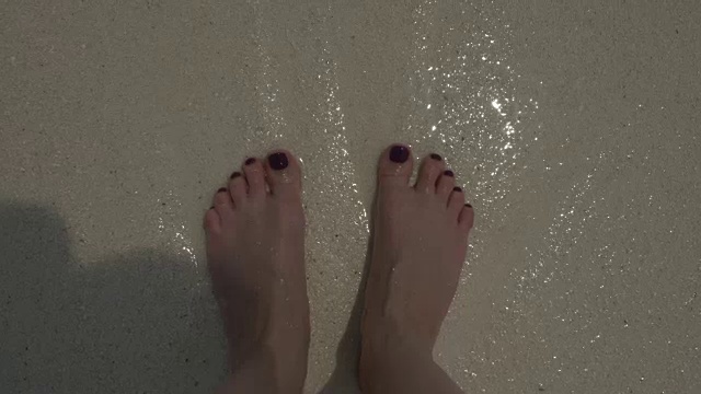 海浪，海水泡沫，沙滩上女人的光脚。视频下载