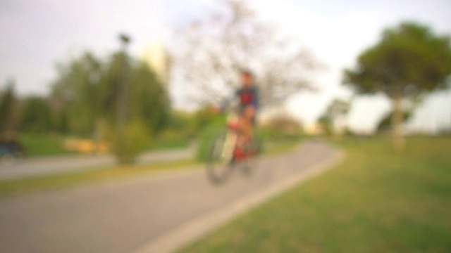 人们骑着散焦的自行车，散景的背景城市公园视频下载