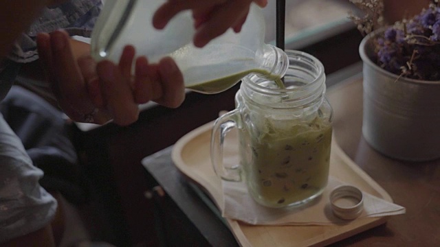 用冰玻璃杯盛着的热绿茶放在木桌上。视频下载
