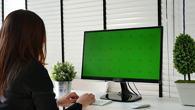 在办公室里使用电脑绿屏的女商人视频素材