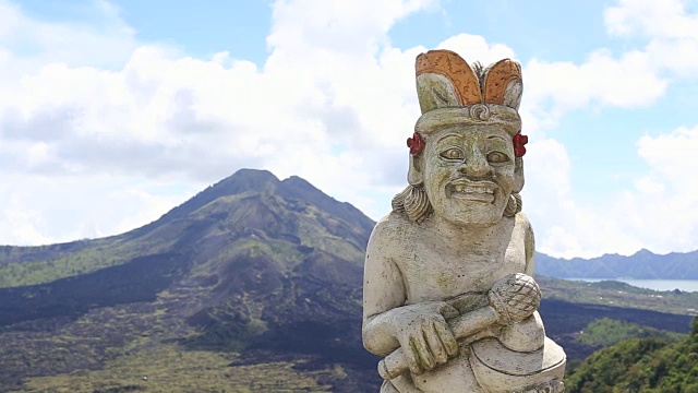 以巴图尔火山为背景的传统雕塑。岛印尼巴厘岛视频下载