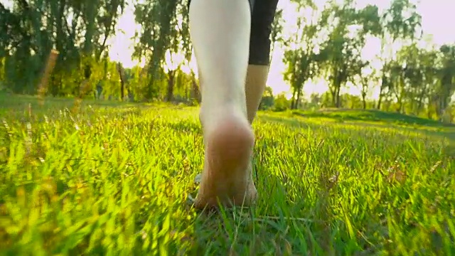 夏天的时候，女人的脚走在草地上视频素材