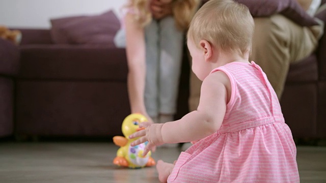 婴儿在地板上玩玩具。可爱的宝贝喜欢在房间里散步视频下载