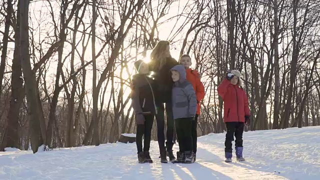 在冬天的公园里，妈妈和儿子们对着相机挥手视频素材