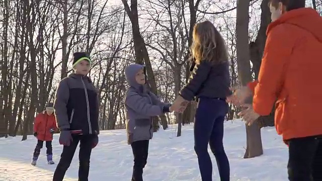 年轻的女人和她的儿子在冬季公园玩得开心视频素材