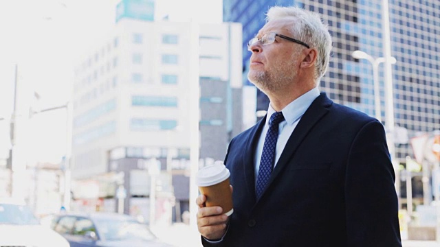 高级商人在城市街道上喝咖啡视频素材