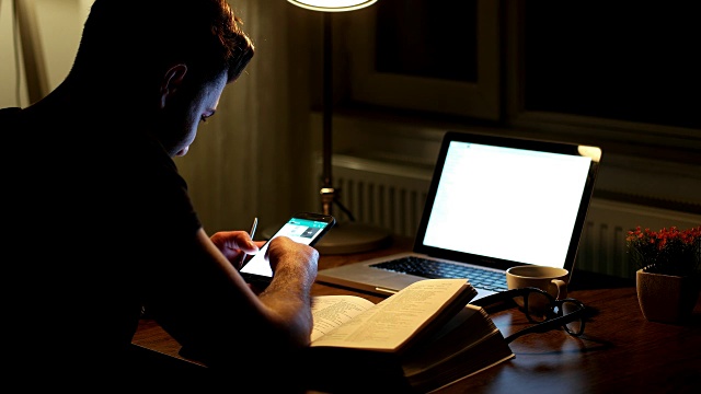 男人的手在晚上用电脑键盘打手机视频下载