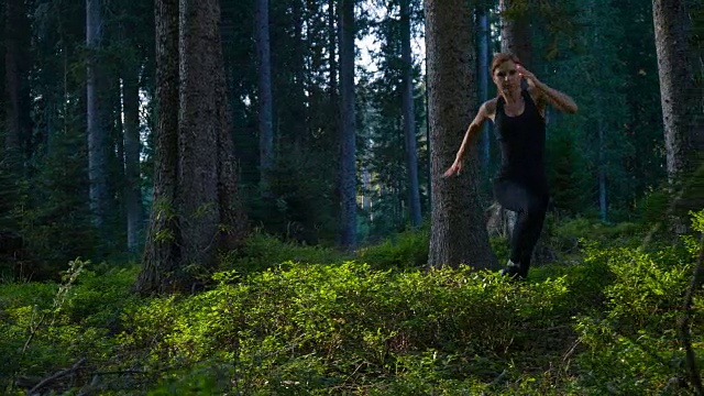 以健康为导向的女性跑步者通过森林视频素材