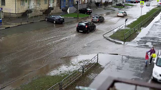 雨中，汽车在满是脏水的道路上行驶。视频素材