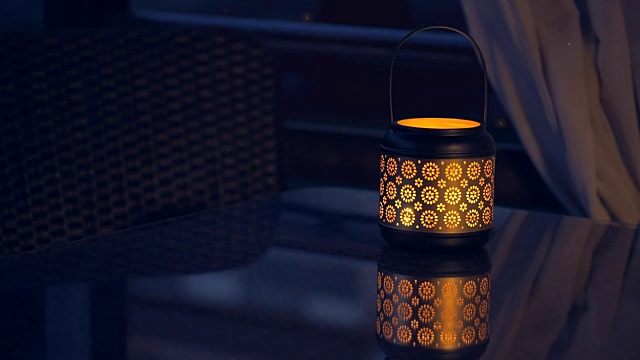 桌上点着蜡烛的灯笼，晚上萤火虫的魔力。视频素材