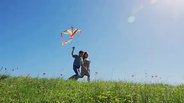 小男孩和小女孩喜欢放风筝散步视频素材