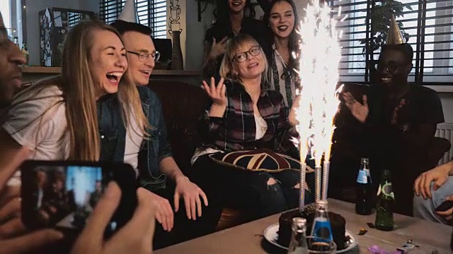 情绪激动的生日女孩感谢快乐的多民族朋友的生日派对与闪闪发光的蛋糕慢镜头视频素材