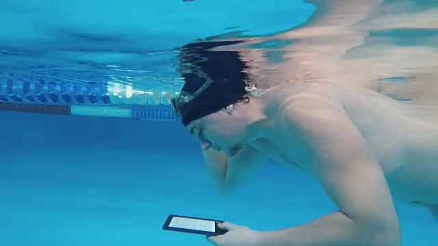 人们在水下读电子书。视频素材