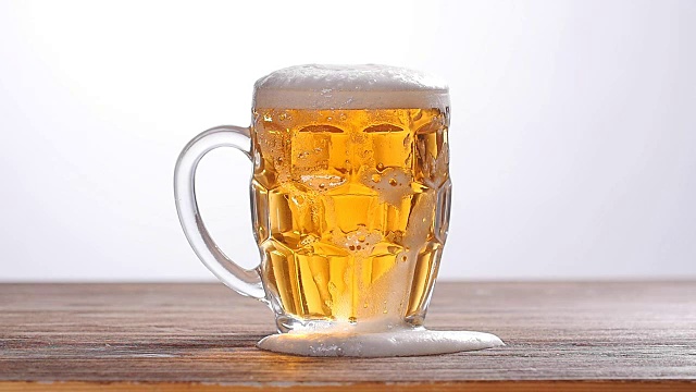 啤酒倒进白色背景的玻璃杯里视频下载