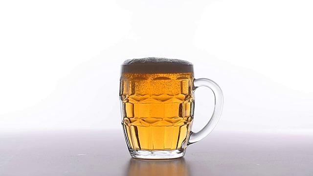 啤酒倒进白色背景的玻璃杯里视频下载