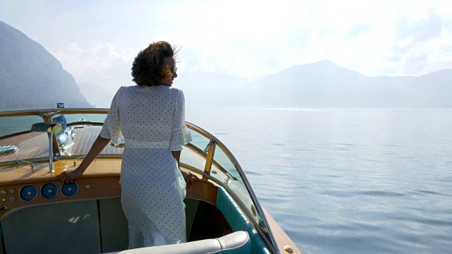 一名女子在意大利湖上的一艘经典的豪华木船上。——慢动作视频素材