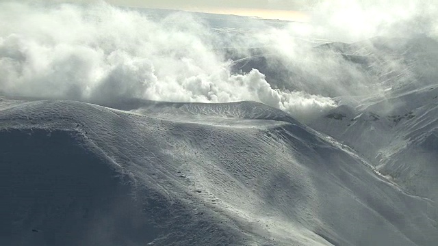 在白雪皑皑的山峰上空，蒸汽从火山口升起。日本。视频素材