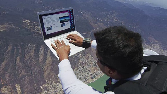 跳伞者在自由落体时用笔记本电脑工作视频素材