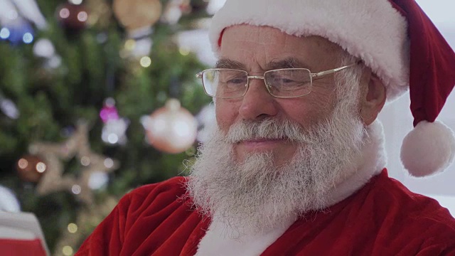 圣诞老人坐着笑着读一本有趣的书视频下载