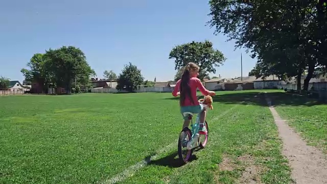 妈妈教女儿骑自行车视频素材
