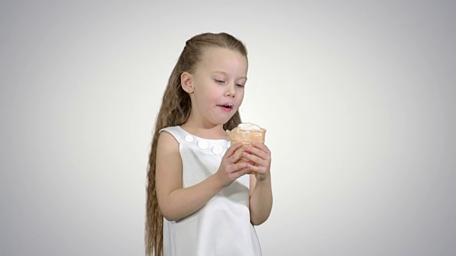 白色背景上吃着冰淇淋的小女孩视频下载