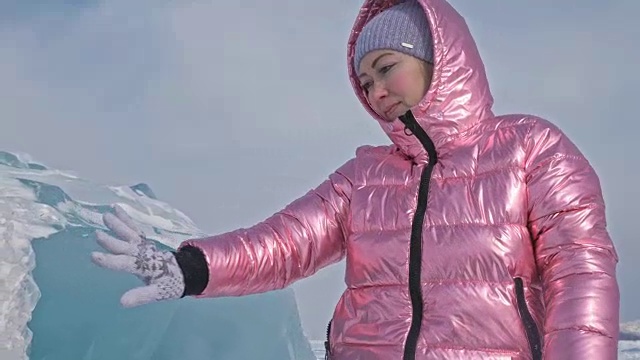一个女孩走在贝加尔湖破裂的冰面上。一名女旅行者探索并看着一块浮冰。这是自然界中最神奇最纯净的地方。冰环绕着旅行者所有的旅程。视频下载