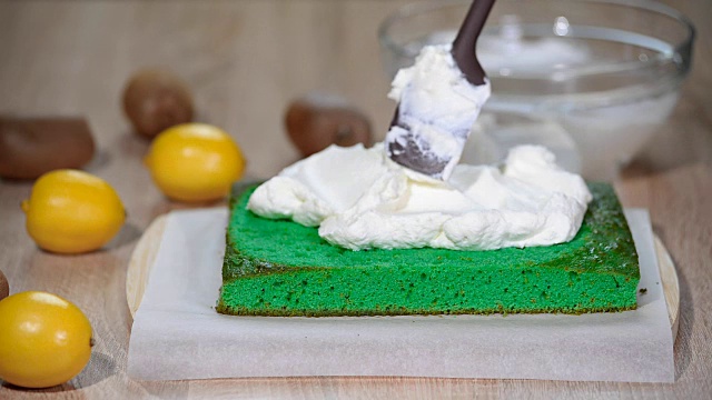 将马斯卡泊尼乳酪涂在绿色海绵蛋糕上。视频下载