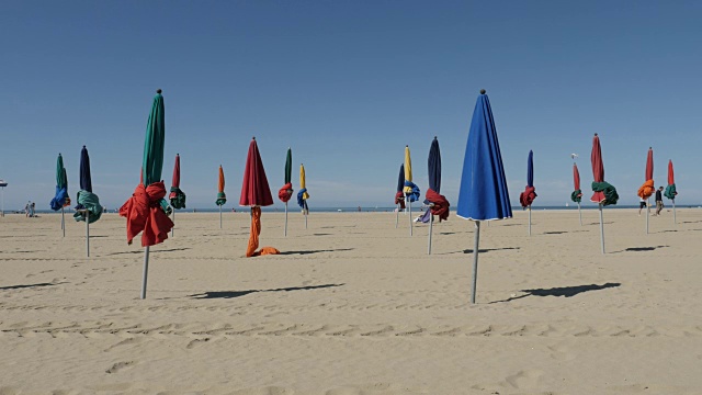 著名的电影节城市海滩用五颜六色的遮阳伞遮阳，由天缓慢倾斜的镜头视频下载