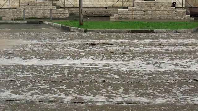 汽车在雨中行驶在被洪水淹没的道路上，慢镜头。视频素材