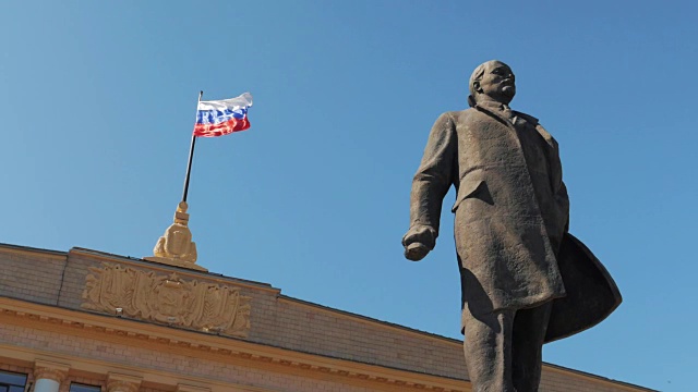 弗拉基米尔列宁的雕像在俄罗斯国旗的背景视频素材