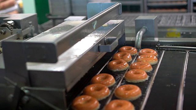 新鲜的甜甜圈漂浮在工厂机器的油视频素材