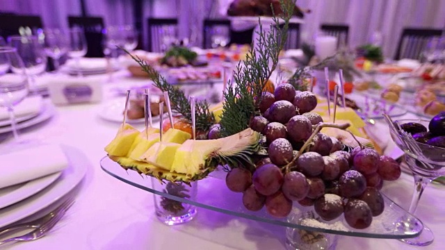 餐厅宴席上的水果和食物，宴席上的菠萝片和葡萄串，宴会厅装饰，餐厅内部视频素材