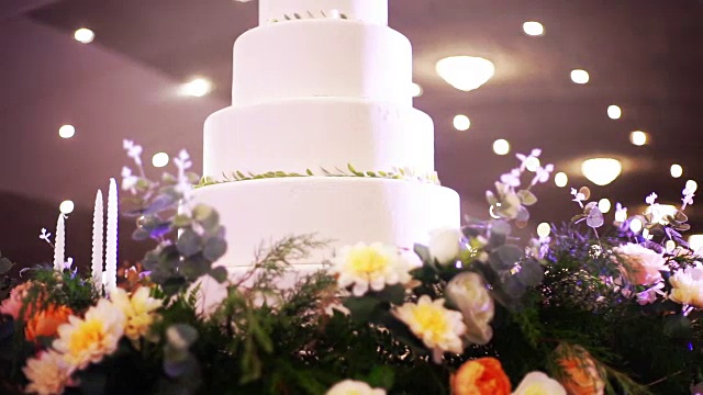 美丽的婚礼蛋糕装饰鲜花和蜡烛在婚宴上。视频素材