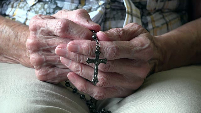 一位年长妇女手握念珠祈祷视频素材