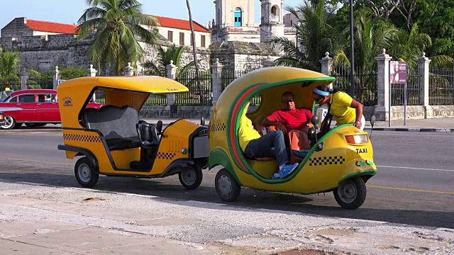 古巴哈瓦那:可可出租车停在El Malecon大道上视频下载