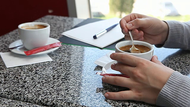 女人在咖啡馆喝咖啡，同时做笔记的日常计划业务议程视频素材