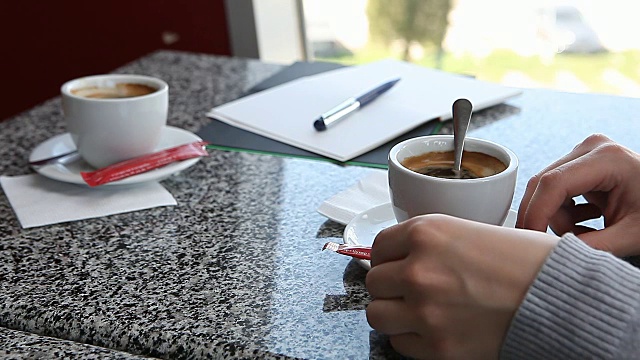 女人将糖加入咖啡并搅拌视频素材