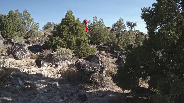 两个男人骑着山地车爬上沙漠中的岩石视频素材