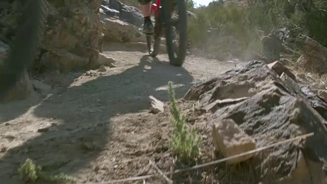 两个骑山地车的人在沙漠的岩石视频素材