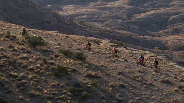 四个骑山地自行车的人在沙漠山上视频素材