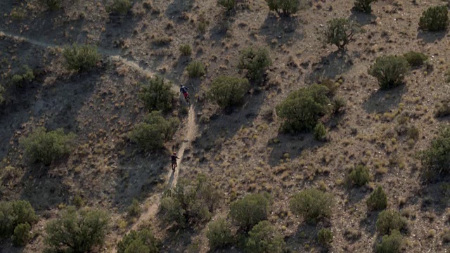 两个男人在沙漠里骑山地自行车视频素材